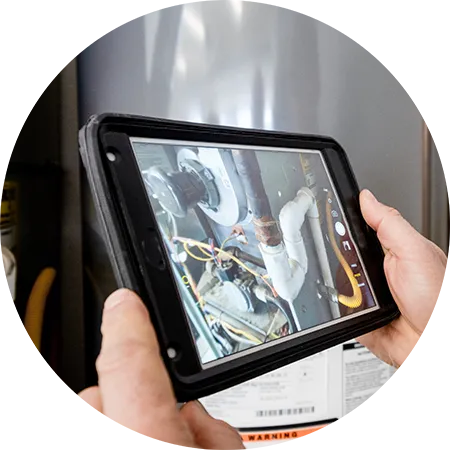 Hands holding a tablet assisting in plumbing.